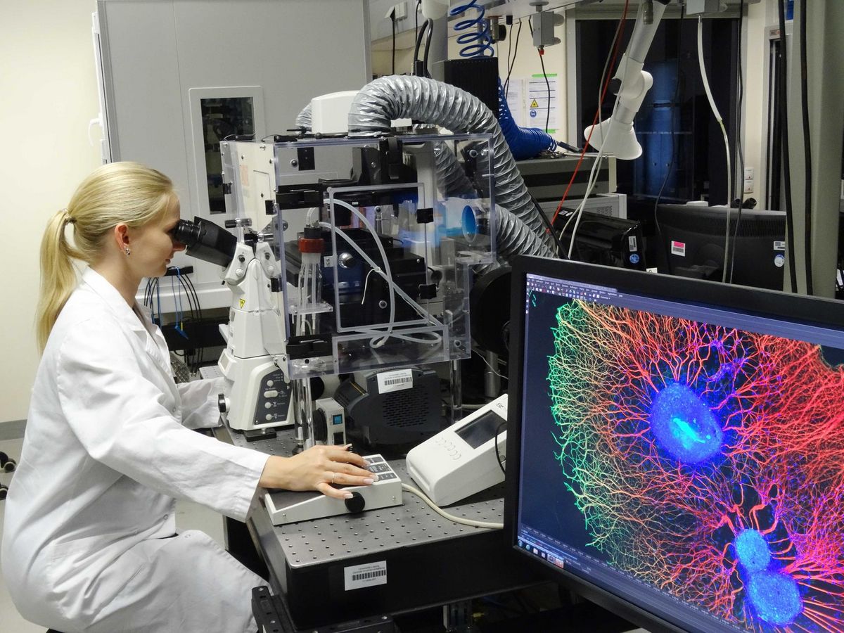 zur Vergrößerungsansicht des Bildes: Foto: Eine Frau im Laborkittel sitzt vor einem Superresolutionsmikroskop am Biotechnologisch-Biomedizinischen Zentrum