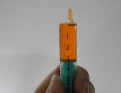 close-up of a hand holding a 3 ml-filled 5-ml-syringe