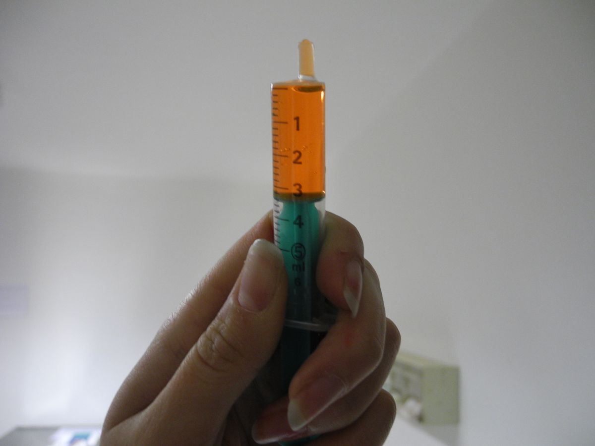 enlarge the image: close-up of a hand holding a 3 ml-filled 5-ml-syringe