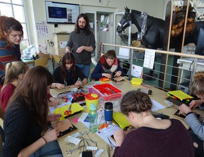 Gruppe von Studierenden übt das Nähen am Modell unter Anleitung der PAUL-Mitarbeiter