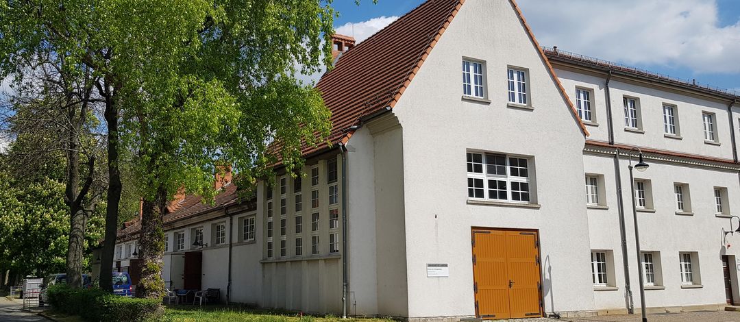 Außenansicht des Klinikgebäudes und der Stallungen - Steingebäude mit roten Dachziegeln