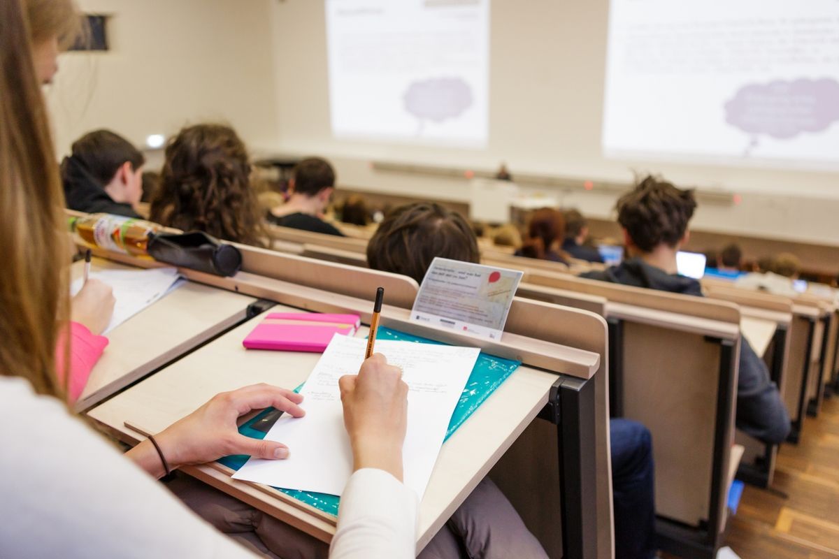 zur Vergrößerungsansicht des Bildes: Foto: Studierende stitzen im Hörsaal